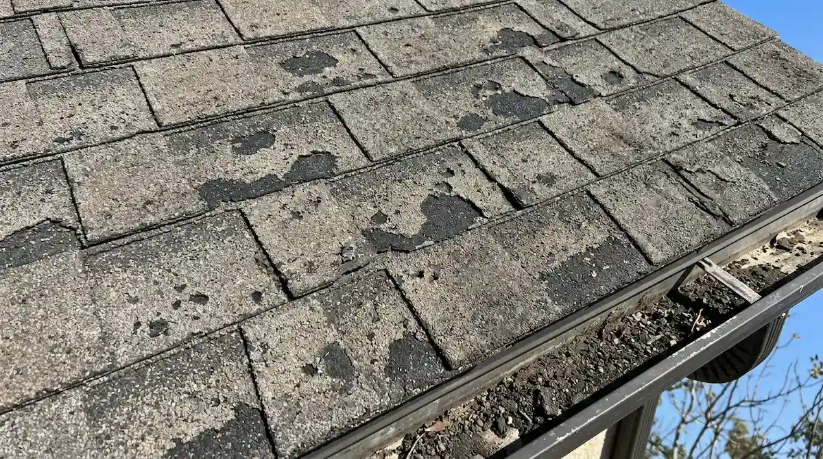 Asphalt shingle roof showing granule loss and UV damage with faded and deteriorated surface on a Pasadena home